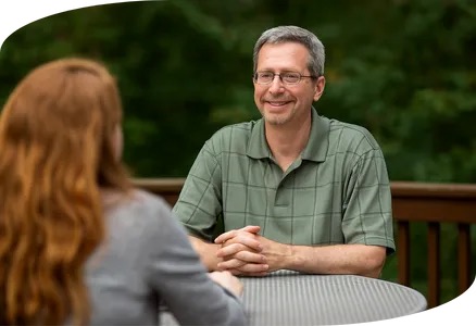 Tim Cureton talking with a client at an outdoor table